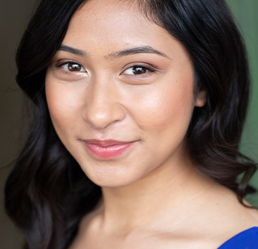 Close-up of a person with dark hair and a calm expression, wearing a blue top.